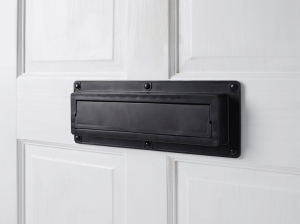 Closed black EcoFlap on a white door